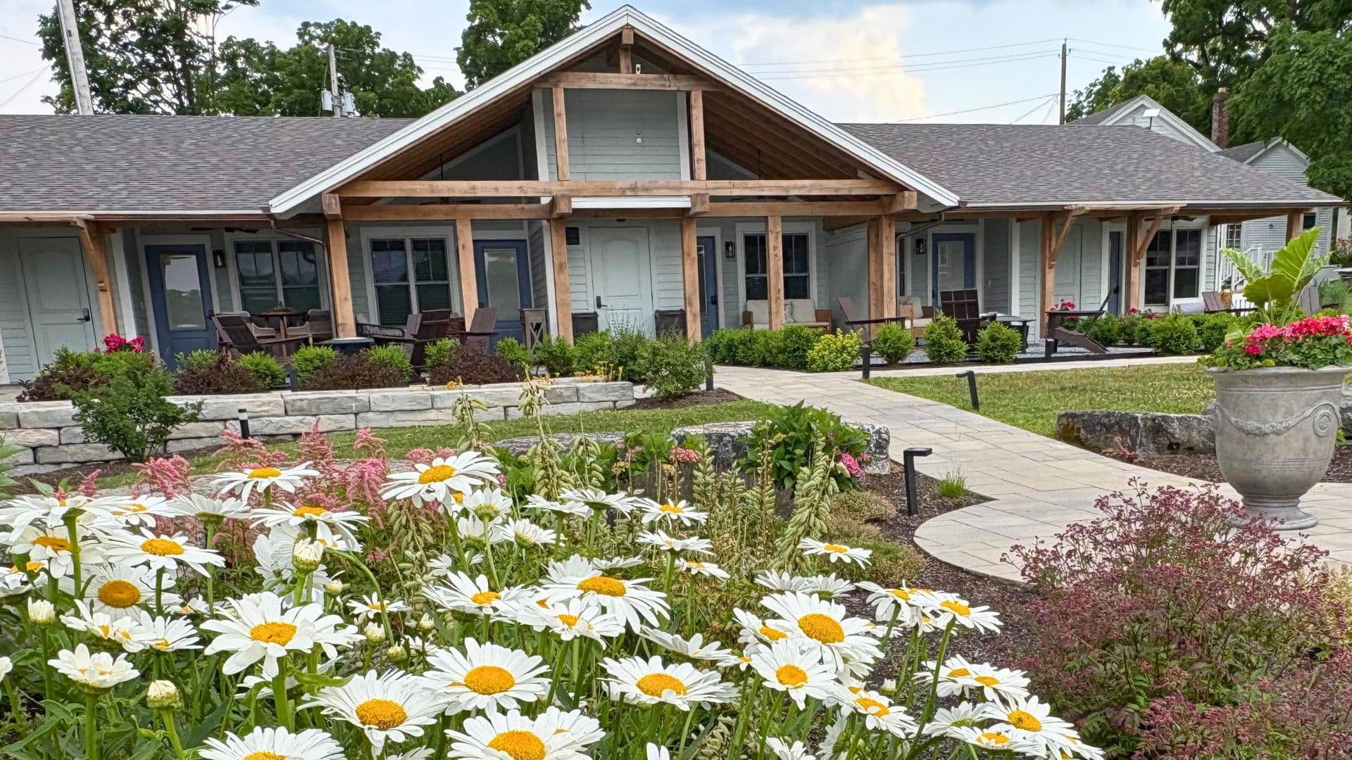 A charming building surrounded by vibrant flowers and well-kept landscaping.
