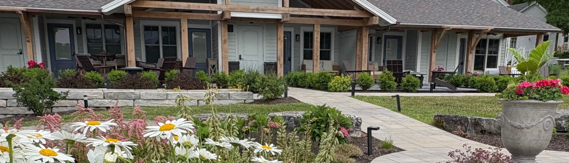 A charming building surrounded by lush gardens and flowers.